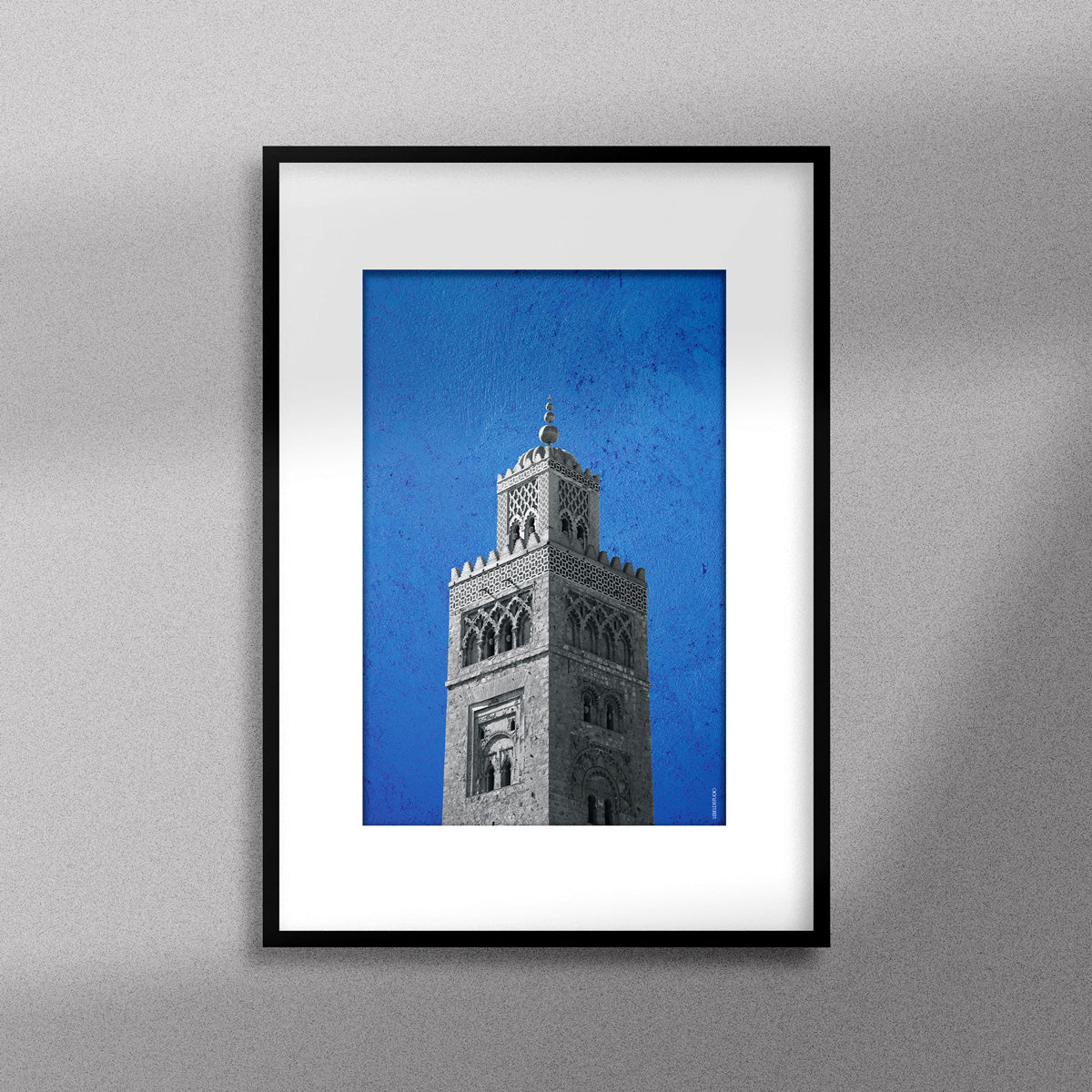 Tableau décoratif représentant la Koutoubia de Marrakech sur un fond bleu, encadré dans un cadre noir - Format A3.
