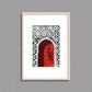Tableau décoratif d'une porte marocaine en rouge, sur un fond de zellige marocain en noir et blanc, encadré dans un cadre en bois - Format A4