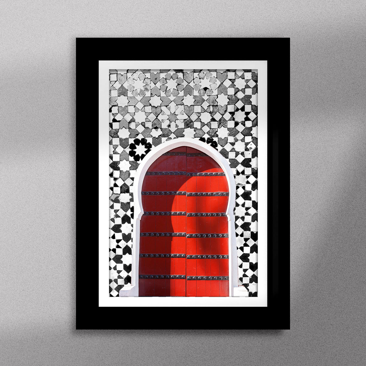 Tableau décoratif d'une porte marocaine en rouge, sur un fond de zellige marocain en noir et blanc, encadré dans un cadre en noir - Format A5
