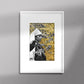 Tableau décoratif représentant un portrait d'une femme amazighe portant la fibule sur un fond de zellige marocain avec des feuilles d'or, encadré dans un cadre blanc - Format A4.