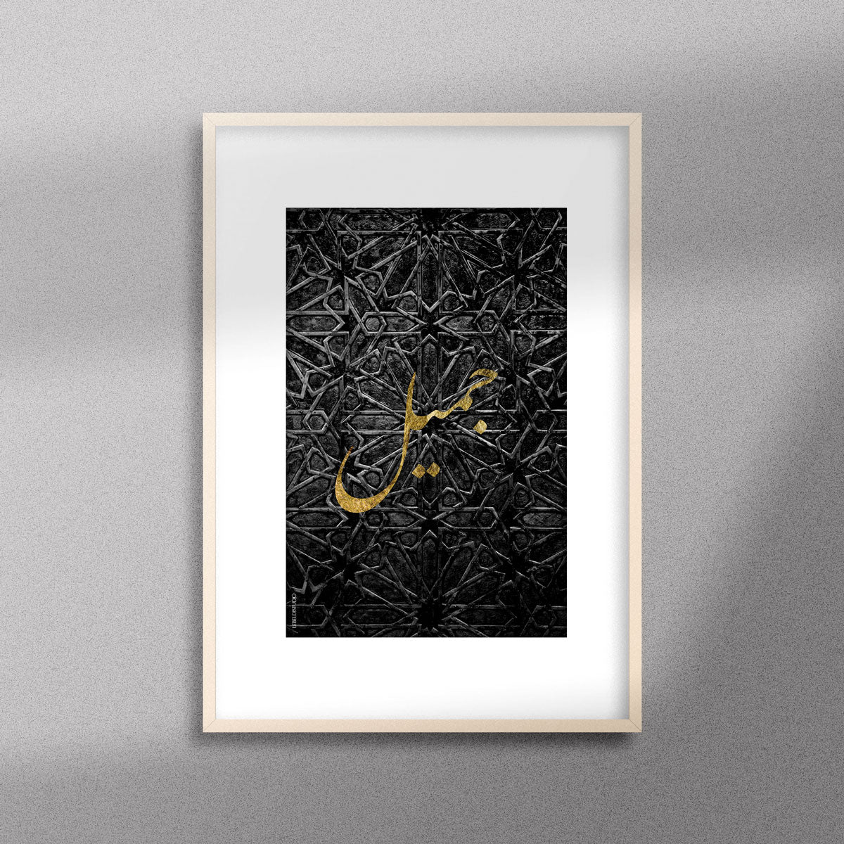 Tableau décoratif avec le mot "Jamil" qui signifie "beau" en doré sur un fond noir de motif artisanal marocain, encadré dans un cadre en bois.