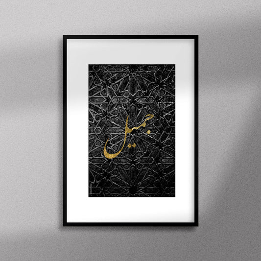 Tableau décoratif avec le mot "Jamil" qui signifie "beau" en doré sur un fond noir de motif artisanal marocain. encadré dans un cadre noir - Format A3.