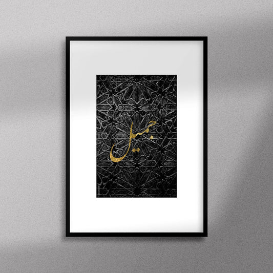 Tableau décoratif avec le mot "Jamil" qui signifie "beau" en doré sur un fond noir de motif artisanal marocain. encadré dans un cadre noir - Format A4.