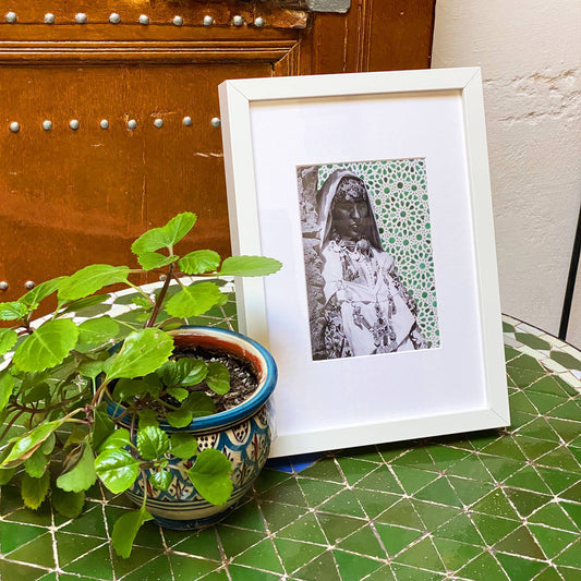Tableau décoratif du portrait d'une femme amazighe sur un zellige beldi vert, encadré dans un cadre blanc - Format A4.