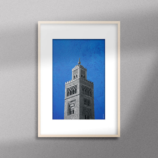 Tableau décoratif représentant la Koutoubia de Marrakech sur un fond bleu, encadré dans un cadre en bois - Format A3.